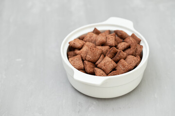 Poster - chocolate cereals in small white bowl on ceramic