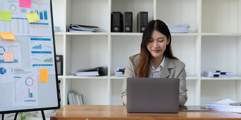 Wall Mural - Beauitul young business asian woman working using computer laptop concentrated and smiling