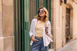 © Look! - Beautiful young caucasian woman in sunglasses dressed posing against backdrop of street. Blonde wears casual clothes in spring weather. Lifestyle concept