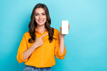 Wall Mural - Photo of cheerful pretty person indicate finger empty space telephone display isolated on blue color background