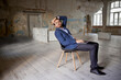 © Lustre Art Group  - Portrait of businessman sitting on chair in empty room and working on laptop. Making professional analytics and countings on company success