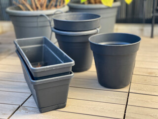 Empty grey plastic flower pots in autumn time on a balcony, preparing a balcony garden for winter, gardening equipment