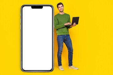 Poster - Photo of attractive cute young guy wear green sweater working modern device empty space isolated yellow color background