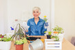 © Jelena Stanojkovic - Hooby biologist pensioner woman arranges the plant in her living room.