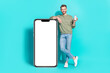 Photo of cheerful man hold telephone show screen empty space wear pullover jeans isolated blue color background