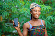 image of beautiful african lady with smart phone outside- excited black woman showing a phone screen