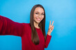 Photo of nice young lady do selfie show v-sign wear eyewear burgundy pullover isolated on blue color background