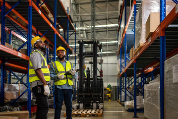 Two warehouse workers checking and controlling boxes in warehouse, Professional warehouse workers moving cardboard boxes by forklift stacker loader, Logistic and business export concept