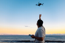 Black Man Launching Drone Near Sea