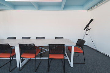 Wall Mural - Interior of cozy light boardroom with table, modern stylish chairs and desktop computer, all ready for corporate meeting. Empty spacious office of business company or creative coworking space. 