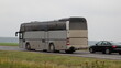 Old gray passenger bus overtake a car on highway closeup . Passenger transportation safety