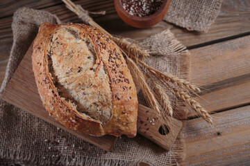 Wall Mural - Fresh baked whole grain bread with oats, flax seeds and sesame seeds on rustic wooden board. Bakery products