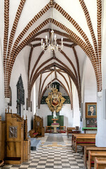 Wall Mural - Aisle of St. John Evangelist church Kosciol Sw. Jana Ewangelisty in historic old town center of Bartoszyce in Poland