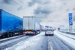 canvas print picture - Lkws Transporter auf deutscher Autobahn im Winter mit Schnee und Schneematsch im Stau