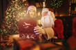 © ZaStock - Santa Claus surprising little girl while open magical box near Christmas tree. New Year concept