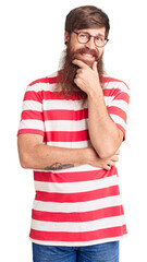 Sticker - Handsome young red head man with long beard wearing casual clothes looking confident at the camera smiling with crossed arms and hand raised on chin. thinking positive.