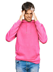 Sticker - Young hispanic man wearing casual pink sweatshirt with hand on head for pain in head because stress. suffering migraine.