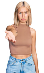 Sticker - Beautiful young blonde woman offering hand depressed and worry for distress, crying angry and afraid. sad expression.