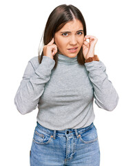 Sticker - Young beautiful woman wearing casual turtleneck sweater covering ears with fingers with annoyed expression for the noise of loud music. deaf concept.