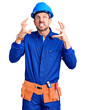 © Krakenimages.com - Young handsome man wearing worker uniform and hardhat angry and mad raising fist frustrated and furious while shouting with anger. rage and aggressive concept.
