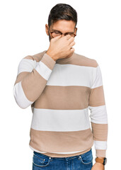 Wall Mural - Handsome man with beard wearing casual clothes and glasses tired rubbing nose and eyes feeling fatigue and headache. stress and frustration concept.