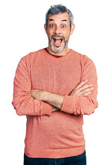 Wall Mural - Middle age hispanic man with grey hair with arms crossed gesture celebrating crazy and amazed for success with open eyes screaming excited.