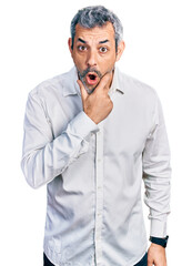 Sticker - Middle age hispanic with grey hair wearing casual white shirt looking fascinated with disbelief, surprise and amazed expression with hands on chin