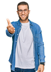 Wall Mural - Young caucasian man wearing casual clothes smiling friendly offering handshake as greeting and welcoming. successful business.