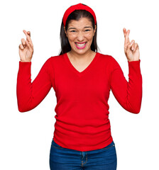 Sticker - Young hispanic woman wearing casual clothes gesturing finger crossed smiling with hope and eyes closed. luck and superstitious concept.