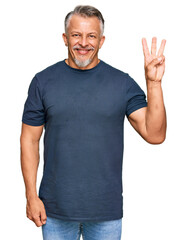 Canvas Print - Middle age grey-haired man wearing casual clothes showing and pointing up with fingers number three while smiling confident and happy.