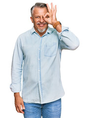 Canvas Print - Middle age grey-haired man wearing casual clothes doing ok gesture with hand smiling, eye looking through fingers with happy face.