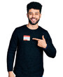 © Krakenimages.com - Young arab man with beard wearing hello my name is sticker identification smiling happy pointing with hand and finger