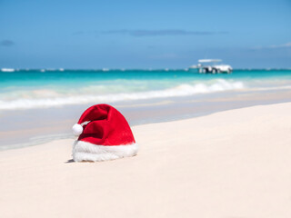 Wall Mural - Santa Claus Hat on sandy beach. Tropical New year celebration