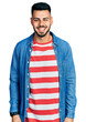 © Krakenimages.com - Young hispanic man with beard wearing casual denim jacket winking looking at the camera with sexy expression, cheerful and happy face.