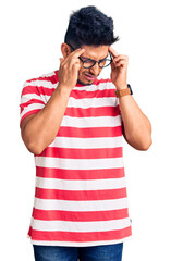 Sticker - Handsome latin american young man wearing casual clothes and glasses with hand on head, headache because stress. suffering migraine.