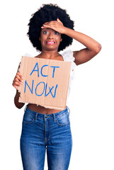 Poster - Young african american woman holding act now banner stressed and frustrated with hand on head, surprised and angry face