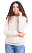 © Krakenimages.com - Beautiful kid girl with curly hair wearing casual clothes looking confident at the camera with smile with crossed arms and hand raised on chin. thinking positive.