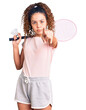 © Krakenimages.com - Beautiful kid girl with curly hair holding badminton racket and shuttlecock pointing with finger to the camera and to you, confident gesture looking serious