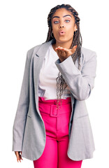 Poster - Young african american woman with braids wearing business clothes looking at the camera blowing a kiss with hand on air being lovely and sexy. love expression.