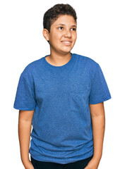 Wall Mural - Teenager hispanic boy wearing casual clothes looking away to side with smile on face, natural expression. laughing confident.