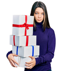 Poster - Young brunette girl with long hair holding gifts depressed and worry for distress, crying angry and afraid. sad expression.