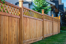 Nice New Wooden Fence Around House. Wooden Fence With Green Lawn. Street Photo