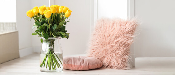 Vase with beautiful yellow roses in interior of room