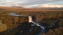Oxararfoss Waterfall With Snowy Mountain In Background. Thingvellir National Park, Iceland. Aerial Drone Orbiting