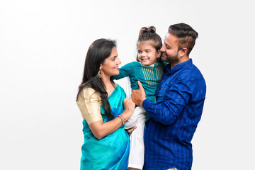 Wall Mural - Happy indian couple with her daughter standing on white background.