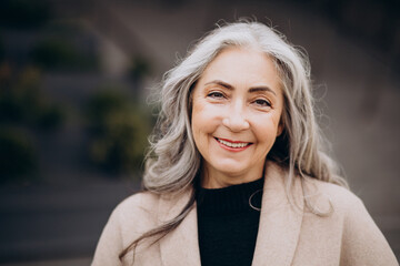 Portrait of elderly woman with grey hair outside the street