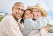 © Jade M/peopleimages.com - Mom, dad and child hug at the beach on family vacation, holiday and enjoying weekend. Love, affection and multicultural parents with happy girl in portrait smile, bond and embrace by ocean together
