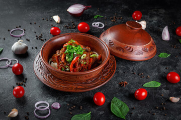 Canvas Print - Traditional Kazakh dish Kuirdak. Aromatic roast of by-products, lamb meat with lots of onions and vegetables in a clay pot