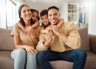 Family, mother and father with hugging kids relaxing on living room sofa with smile for quality bonding time at home. Portrait of happy mama, dad and children smiling in happiness for break together