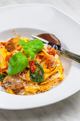 Wall Mural - pasta tagliatelle with tomato sauce,champignon and basil leaves